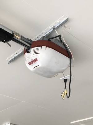 Chamberlain motor repair process in garage with overhead door mechanism being serviced Chamberlain motor repair process in garage with overhead door mechanism being serviced