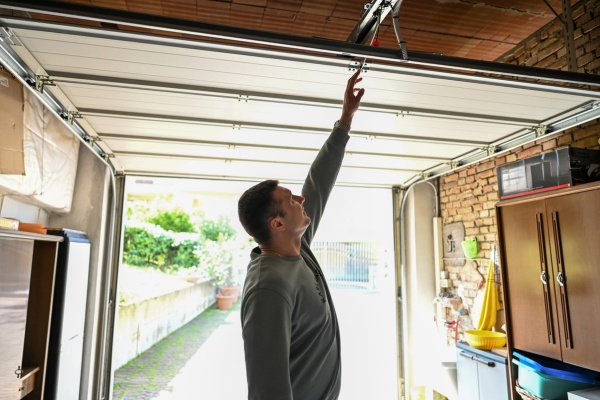 Myq opener repair technician performing adjustments in a residential garage during daytime Myq opener repair technician performing adjustments in a residential garage during daytime