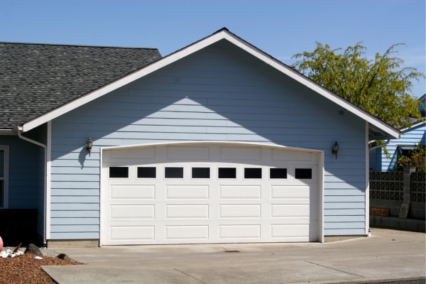 Overhead door replacement project in Edmonton featuring a modern white garage door on a residential home A residential home in Edmonton