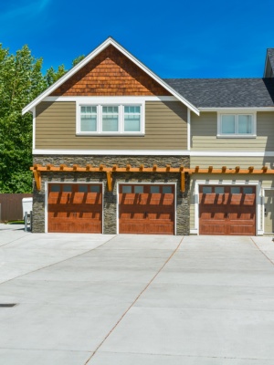 Overhead door repair service in Edmonton featuring elegant wooden garage doors and modern home design Overhead door repair service in Edmonton featuring elegant wooden garage doors and modern home design