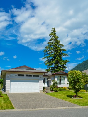 Home exterior view in Edmonton with clear blue sky and lush landscaping on a bright summer day Home exterior view in Edmonton with clear blue sky and lush landscaping on a bright summer day